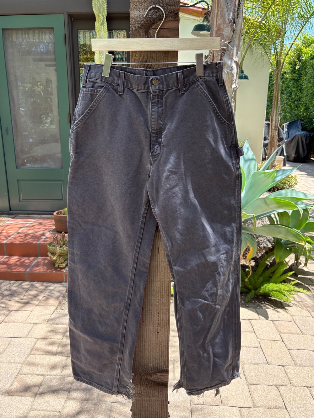 Carhartt grey work pants with shredded cuffs